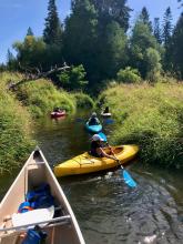 people kayaking down a river